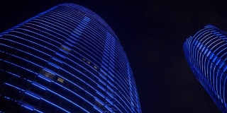 夜晚时分，照亮三亚市海湾公寓综合楼，俯瞰4k中国海南全景