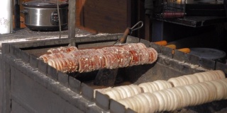 Trdelnik，布拉格流行的圆柱形糕点，用火管烹饪。美味的肉桂味配上巧克力、果酱或鲜奶油。红糖和碎榛子。美味的食物。