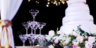 金字塔的空香槟酒杯在婚礼设置倒香槟与模糊的背景。