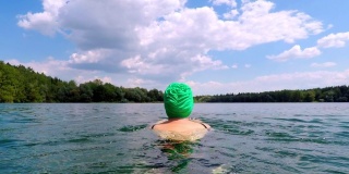 戴着游泳帽在湖里游泳的女人