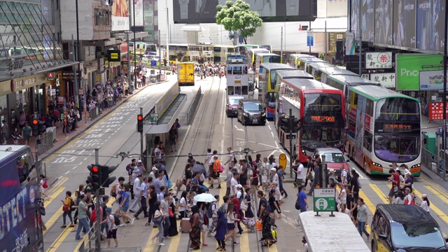 人们走过铜锣湾轩尼诗道，在中环道购物，在香港的法玛斯广场乘电车和火车旅行