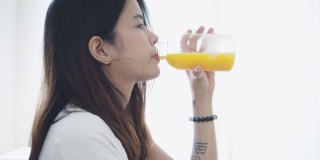 微笑的女人喝着橙汁