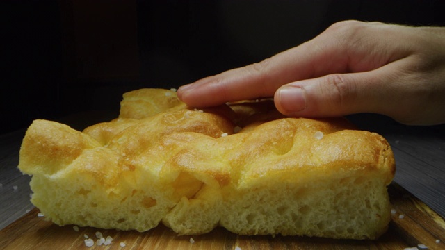 微距幻灯片拍摄的一片佛卡夏面包在黑色的背景。