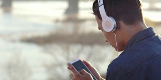 一个十几岁男孩戴着耳机听音乐的特写镜头