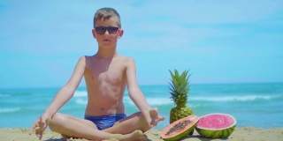 一个男孩坐在海边，在大海的背景下，旁边是奇异的水果