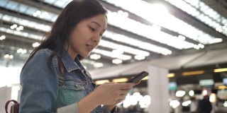 亚洲女性在机场使用智能手机