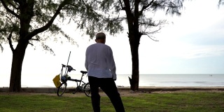 场景慢镜头:早上亚洲老人在公园里练太极，概念健康生活方式，运动
