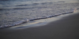 脚在海边的沙滩上留下痕迹，海水会把这些痕迹冲掉