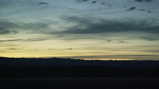 黄昏时分，一辆开着前灯的半挂卡车在科罗拉多西部的高沙漠中行驶