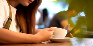 一个亚洲女人的嘴在周末的咖啡馆里喝了一口咖啡