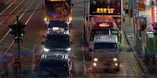 出租车、双层公共汽车、有轨电车在市中心穿过十字路口。