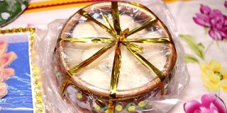 印度甜或甜点——拉斯古拉，著名的孟加拉甜在粘土碗和餐巾在红色的背景，慢镜头