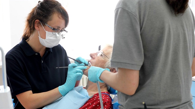牙医正在检查一位老年妇女的牙齿