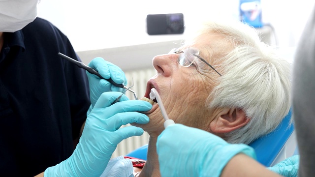 年长的妇女正在牙医那里检查牙齿