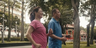 两个活跃的亚洲老年人在公园里动力行走