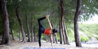 4k/年轻的亚洲苗条女子瑜伽在日落的海滩上，日出的背景。健身、运动、瑜伽、剪影、健康理念。