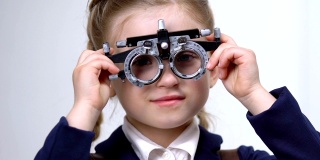 男眼科医生检查女学生的视力，带着荧光镜微笑的孩子，吃药