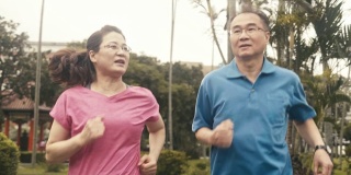 两个活跃的老年人在公园里跑步