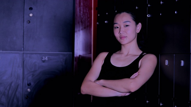 肖像亚洲妇女微笑在健身房。她累了后，密集的交叉健身运动。运动Prep.Martial艺术