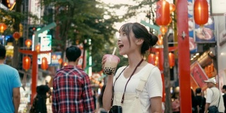台湾千禧女喝着珍珠奶茶走在西门町购物区(慢镜头)