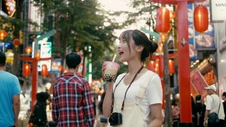 台湾千禧女喝着珍珠奶茶走在西门町购物区(慢镜头)视频素材模板下载