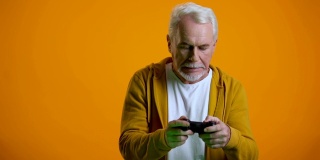 感情用事的老男人拿着操纵杆玩电子游戏，因回合结果而沮丧