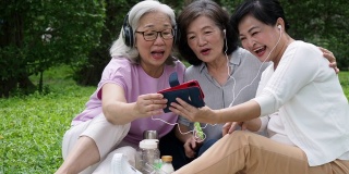 三位女士在公园里一起听音乐