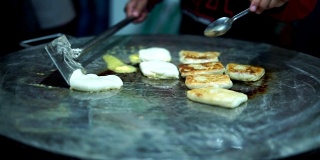 街头小吃摊贩在煎锅上做烤肉