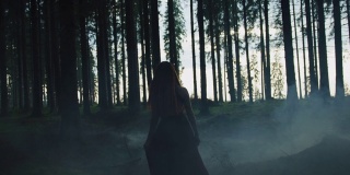 一个女人走在雾蒙蒙的森林里