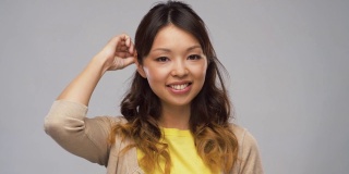微笑的亚洲妇女的肖像触摸她的头发