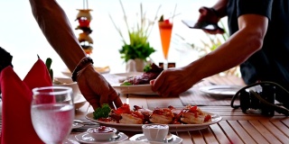 在热带海洋里，人们在木制餐桌上摆放着各种各样的食物