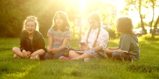 学校放假时，学生们坐在草地上。美丽的女孩戴着眼镜，扎着辫子在夕阳的光线下自拍
