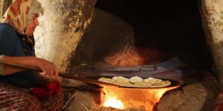 安纳托利亚的妇女正在烹饪坑里做安纳托利亚特有的面包。使用工具;锅、盘、面团、火等。乔鲁姆/土耳其01/12/2016