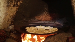 安纳托利亚的妇女正在烹饪坑里做安纳托利亚特有的面包。使用工具;锅、盘、面团、火等。乔鲁姆/土耳其01/12/2016视频素材模板下载