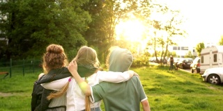 三个孩子，两个女孩和一个男孩在夕阳的背景下走向远处的公园。16、回到学校，快乐的孩子，学校友谊