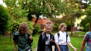 孩子们从学校回来，有趣的跑步，扔书包和笔记本。学年结束了，暑假开始了，开学了视频素材模板下载