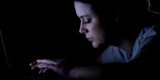 年轻女子在笔记本电脑前睡着了，上夜班，精疲力竭