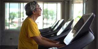 亚洲老年人在健身房里跑步机上散步锻炼。运动，训练，退休，老年，成熟，老年