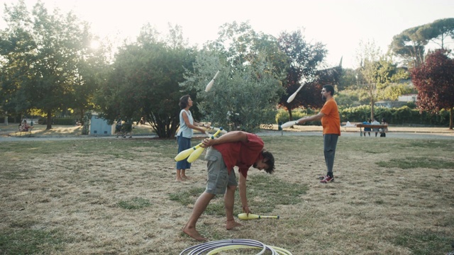 三个年轻的杂耍演员在公园里一起训练