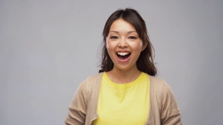 微笑的年轻亚洲女人的肖像在开襟羊毛衫视频素材模板下载