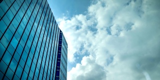 天空与移动的云反射在办公大楼的窗户玻璃上