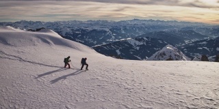 成熟的男人在白雪覆盖的悬崖上徒步旅行