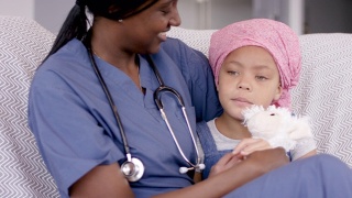 快乐的癌症女孩和家庭看护坐在一起视频素材模板下载