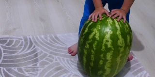 一个大西瓜和一个小男孩，孩子玩整个西瓜，
