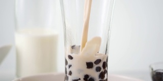 将奶茶倒入饮用杯中，加入台湾流行的珍珠泡。