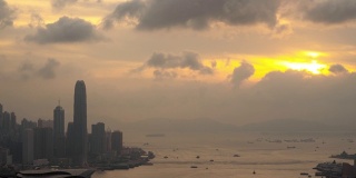 4K时间推移宽拍摄高角度鸟瞰图移动云在摩天大楼城市景观商业金融大厦大厦和水运输物流日落形成Braemar山，中国香港。