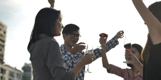 人们庆祝有乐趣和喝葡萄酒在屋顶派对