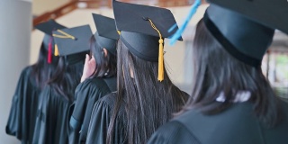 毕业典礼那天，毕业生们在大学里抛帽子。
