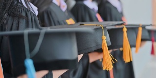 毕业典礼那天，毕业生们在大学里抛帽子。