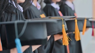毕业典礼那天，毕业生们在大学里抛帽子。视频素材模板下载